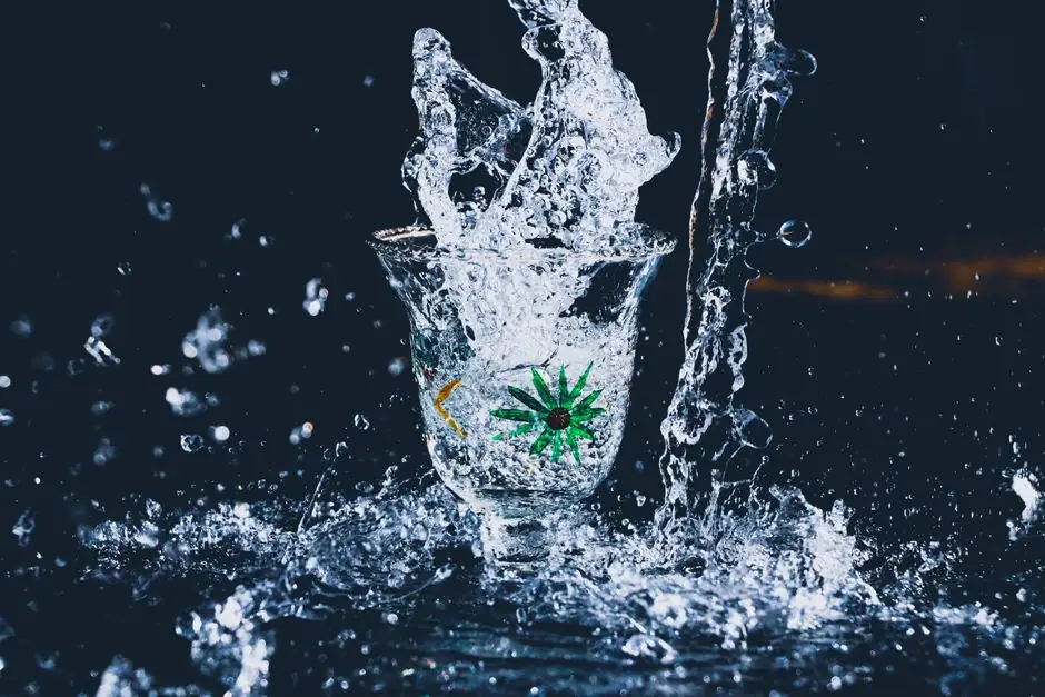 High-speed photo of a water splash in a decorative glass with flower motif.